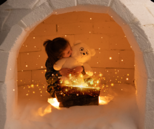 Petite fille faisant un gros câlin à son ours en peluche KANDA dans une ambiance magique, conçu pour apaiser les émotions grâce à ses points d'acupression.